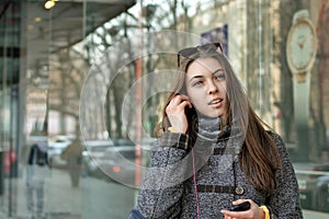 Girl inserts the earpiece into her ear