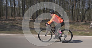 Girl intensively cycling on road bike. Woman rides on bicycle. Female pedaling  on cycle. Triathlon concept