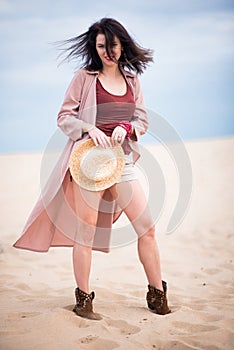 Girl inthe desert with hat dark hair and smile