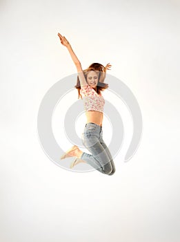 Girl with jeans and pink top jumping energetically