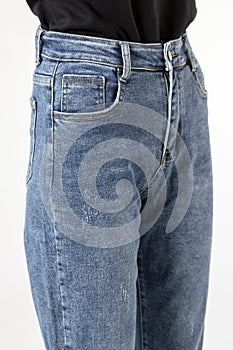 Girl in jeans shows off jeans on white background close up