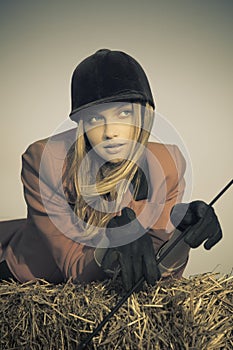 Girl jockey / on a background of blue sky and hay