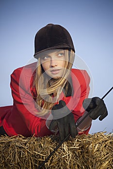 Girl jockey / on a background of blue sky and hay