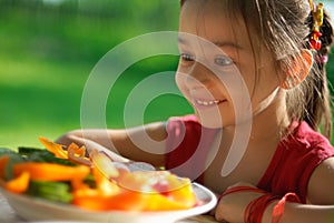 The girl joyfully is surprised to tasty vegetables