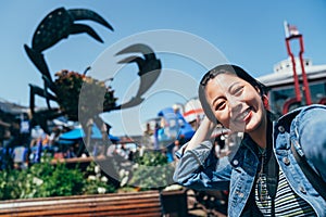 Girl joyfully taking selfie with huge crab sign