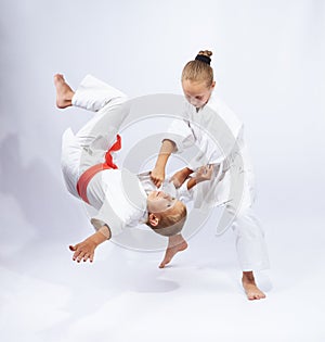 The girl in judogi throws the boy