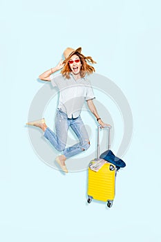 girl jumping appearance with a suitcase on a bright blue background in the Studio. The concept of travel and