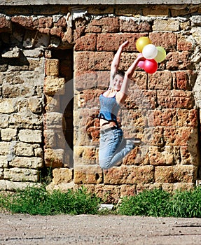 Girl jumping with balloons on grunge background