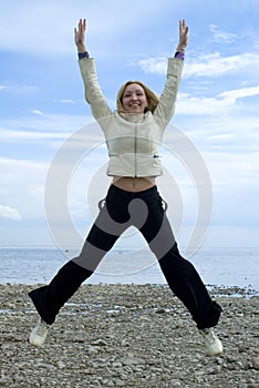 Girl jumping beside Baltic sea