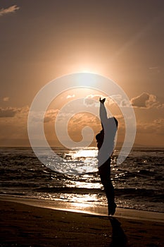 Girl jumping at beach on sunrise