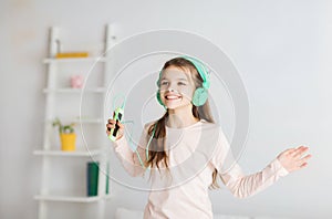 Girl jumping on bed with smartphone and headphones