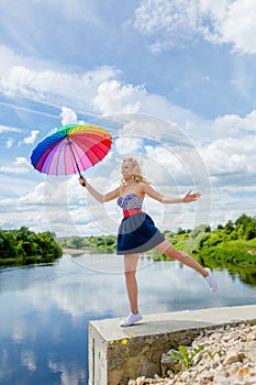 Girl jumping with a colorful umbrella