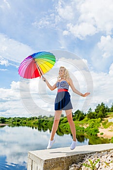 Girl jumping with a colorful umbrella