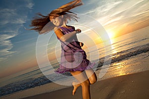 Girl jumping and dancing on beautiful beach.