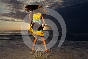 Girl jumping and dancing on beautiful beach.