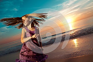 Girl jumping and dancing on beautiful beach.