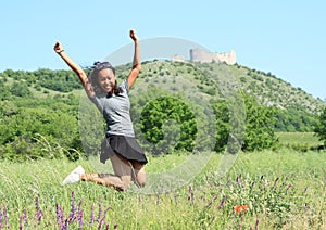 Girl jumping in front of castle Devicky on Palava