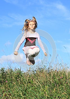 Girl jumping in grass