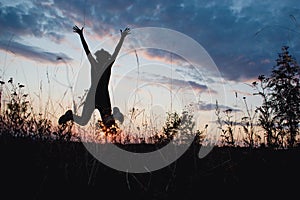 Girl jumping happily in sunset light. Summer , Nature, outdoor, freedom, success, happiness concept