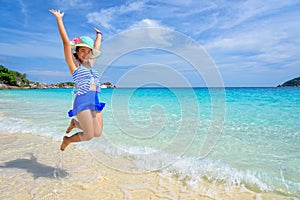 Girl jumping with happy on the beach at Thailand