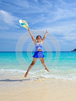 Girl jumping with happy on the beach at Thailand