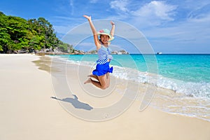 Girl jumping with happy on the beach at Thailand