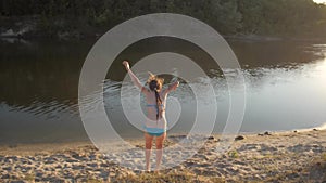 Girl jumping from the hill on beach in sand falls and laughs.