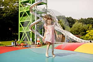 Girl jumping on inflatable trampoline in amusement park