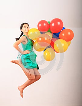 Girl jumping with inflating balloons