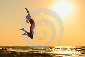 The girl is jumping for joy on the seashore.