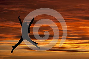 Girl jumping with joy at sunset