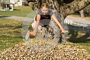 Girl Jumping into Leaf Pile