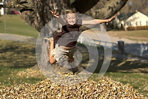 Girl Jumping into Leaf Pile