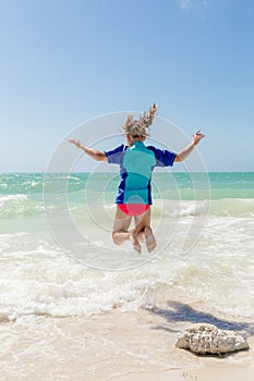 Girl jumping in the ocean photo