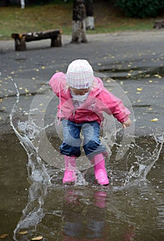 Girl jumping in puddles