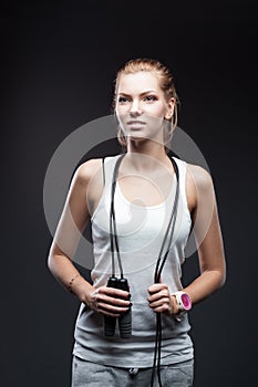 Girl with jumping-rope on dark background