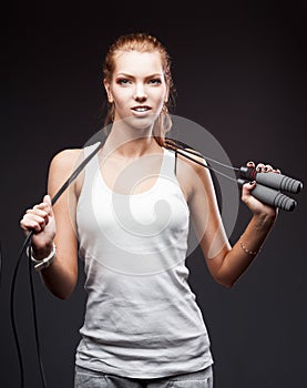 Girl with jumping-rope on dark background