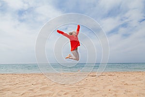 Girl jumping on a sandy beach sea shore