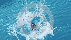 Girl jumping into sea water form yacht. Child diving into sea from boat