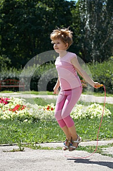 Girl jumping on a skipping rope in the park
