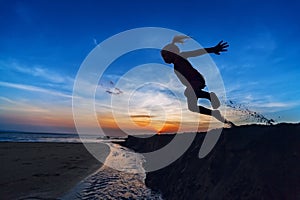 Girl jumping on the sunset beach