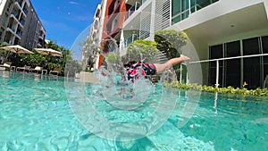 Girl is jumping to swimming pool. Slow motion video