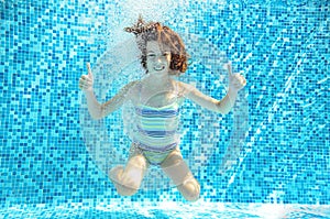 Girl jumps, dives and swims in pool underwater, happy active child has fun under water, kid sport