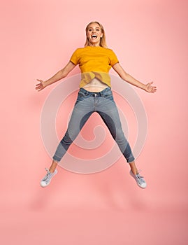 Girl jumps on pink background. Concept of freedom, energy and vitality