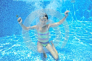 Girl jumps and swims in pool underwater