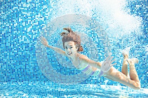 Girl jumps and swims in pool underwater, child has fun in water