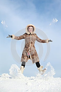 Girl jumps and throw snow hands and feet