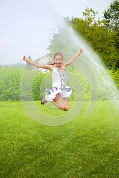 Girl jumps under spray drops