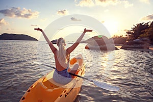 Girl on kayak sea at sunset, healthy lifestyle design. Sport, recreation, adventure outdoors.