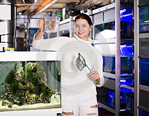 Girl keeps aquarian fish net and water container